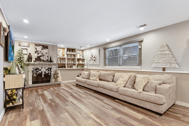 living room with built in shelves and light wood-type flooring