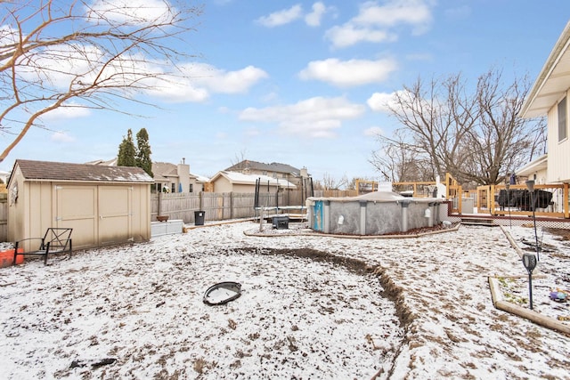 yard covered in snow with a swimming pool side deck