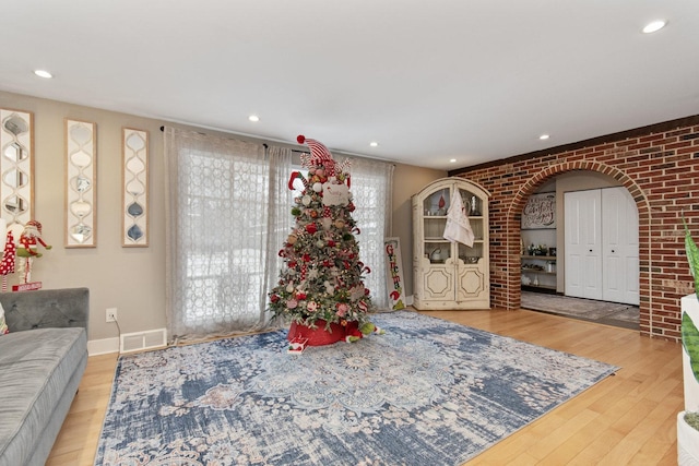 interior space with light hardwood / wood-style floors and brick wall