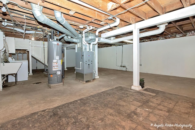 basement with heating unit, washer / clothes dryer, and water heater