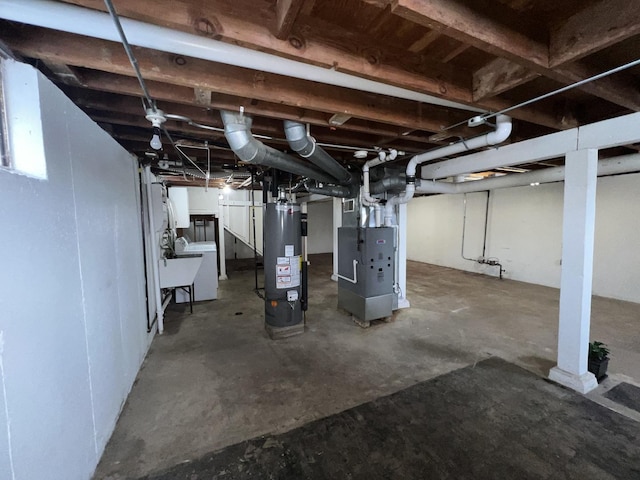 basement with washer / clothes dryer, sink, heating unit, and gas water heater