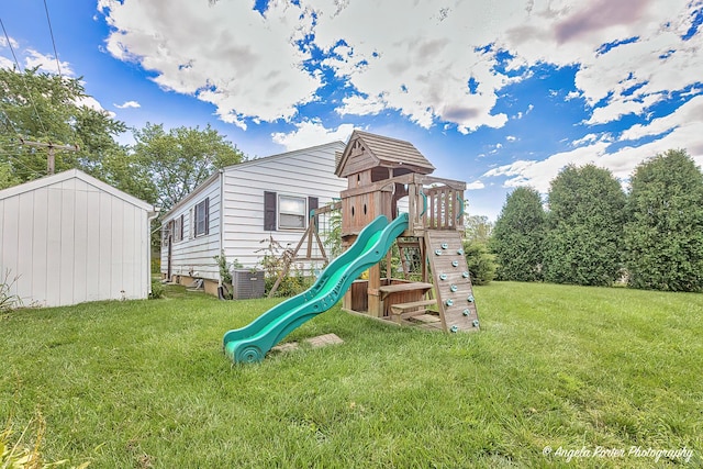 view of play area with cooling unit and a lawn