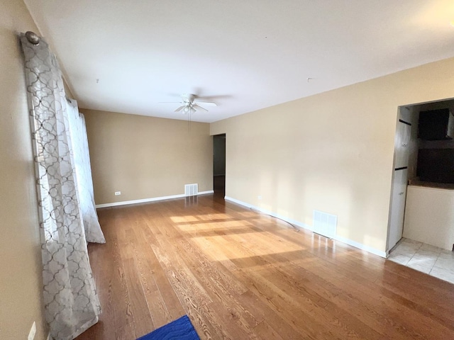 spare room featuring ceiling fan and light hardwood / wood-style floors