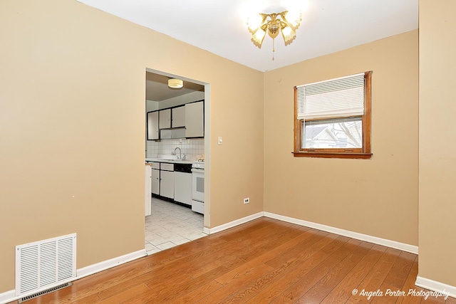 empty room featuring sink and light hardwood / wood-style flooring