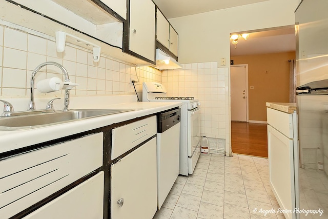 kitchen featuring light tile patterned flooring, white cabinetry, sink, tile walls, and white appliances