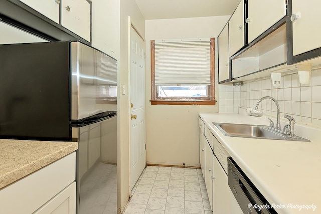 kitchen featuring backsplash, stainless steel fridge, sink, and white cabinets