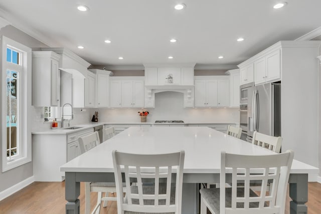 kitchen with sink, backsplash, a spacious island, a breakfast bar area, and appliances with stainless steel finishes