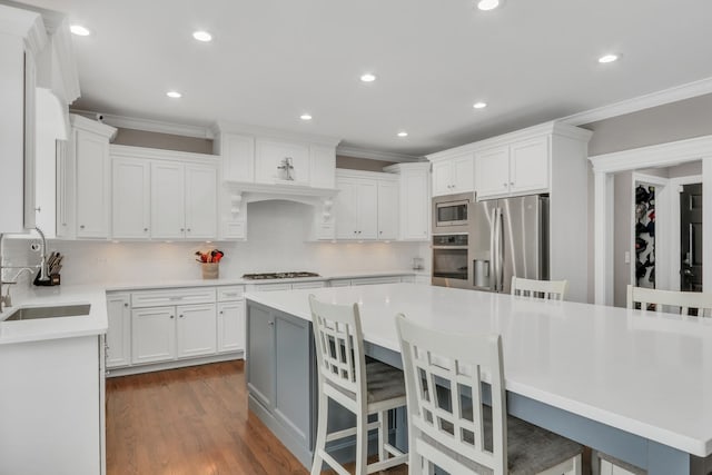 kitchen featuring a center island, tasteful backsplash, a breakfast bar area, white cabinets, and appliances with stainless steel finishes