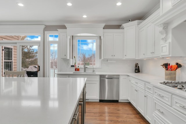 kitchen with backsplash, white cabinetry, and appliances with stainless steel finishes