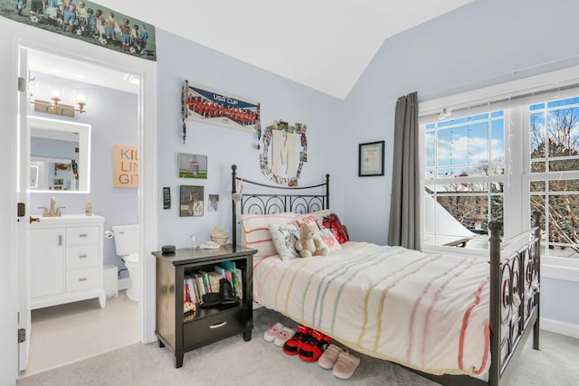 carpeted bedroom featuring sink and vaulted ceiling