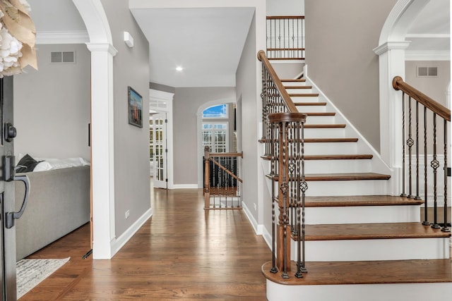 entryway featuring dark hardwood / wood-style floors, ornamental molding, and decorative columns