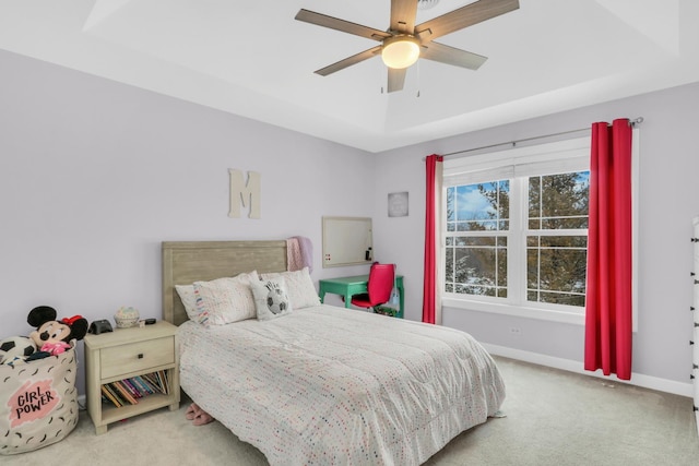 bedroom with carpet flooring, ceiling fan, and a raised ceiling