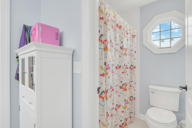 bathroom with tile patterned floors, toilet, and walk in shower