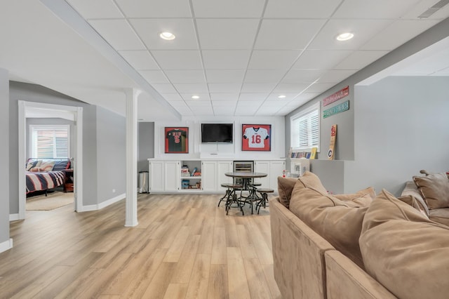 living room featuring a paneled ceiling, light hardwood / wood-style floors, and beverage cooler