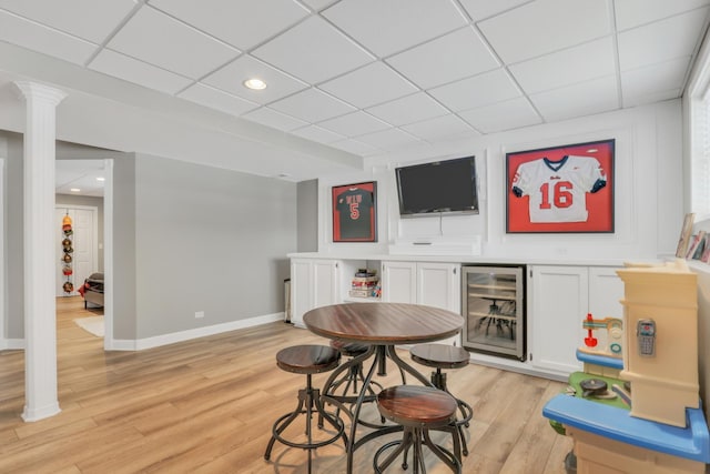 bar featuring white cabinetry, wine cooler, a drop ceiling, and light hardwood / wood-style flooring