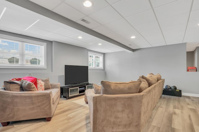 living room featuring a drop ceiling and light hardwood / wood-style floors