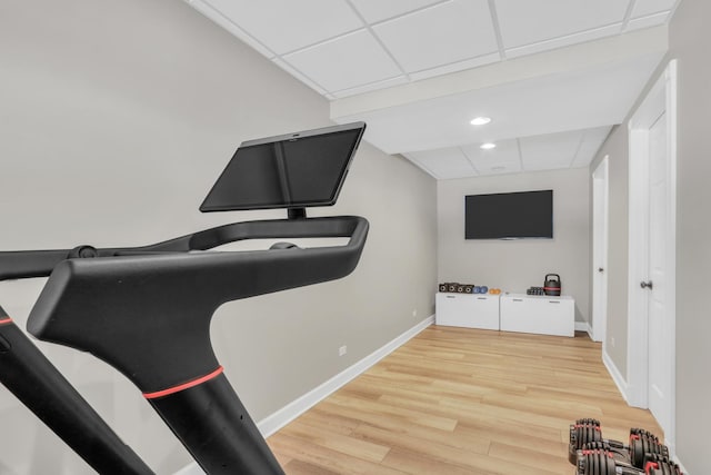 exercise room with wood-type flooring and a drop ceiling