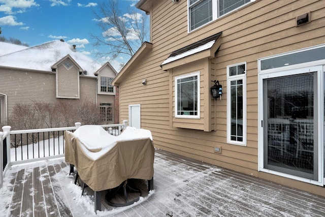 snow covered deck with a grill