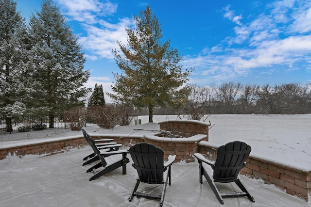 snow covered patio featuring an outdoor fire pit