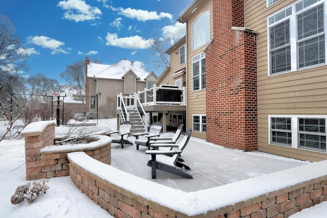 snow covered patio featuring a deck