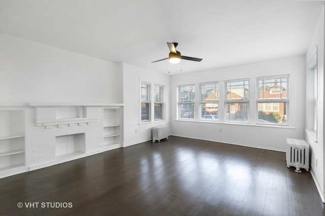 unfurnished living room with a fireplace, radiator heating unit, dark hardwood / wood-style flooring, and ceiling fan