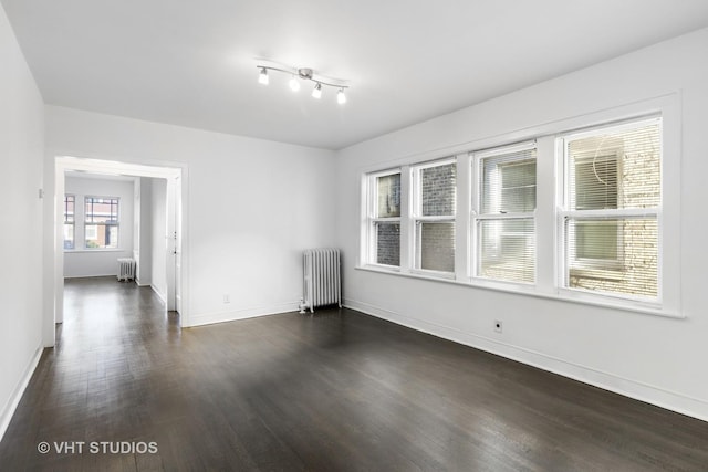 empty room featuring dark hardwood / wood-style floors and radiator