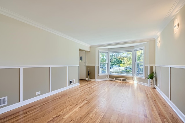 empty room with light wood-type flooring and ornamental molding