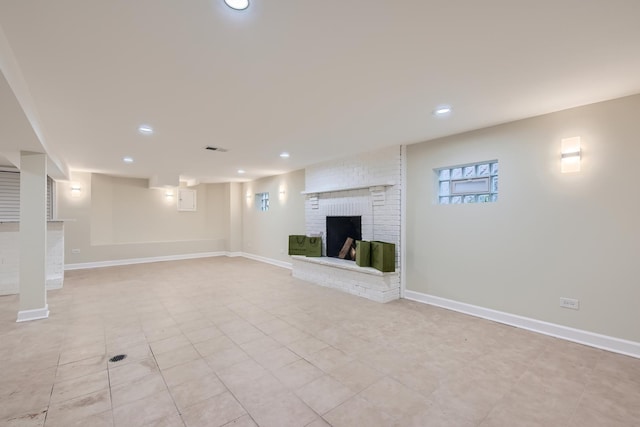 basement featuring light tile patterned floors and a brick fireplace