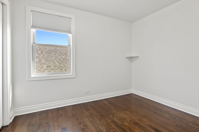 unfurnished room with dark wood finished floors and baseboards