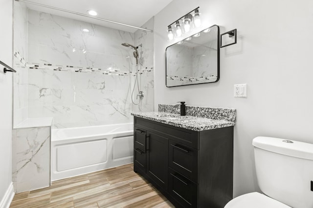 bathroom featuring vanity, wood finished floors, recessed lighting, shower / bath combination, and toilet