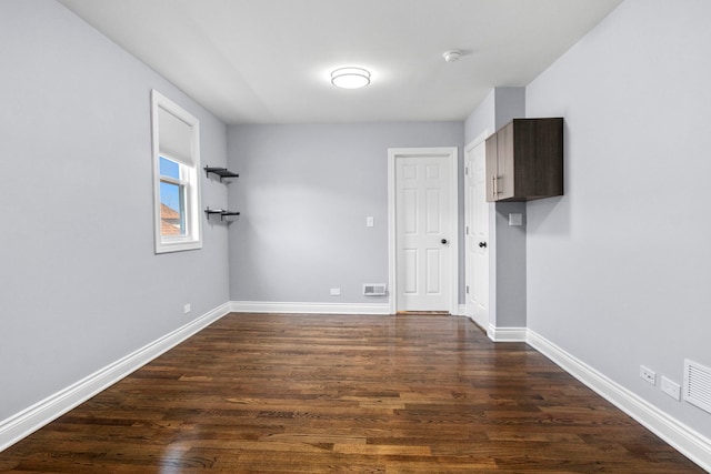 spare room with dark wood-type flooring and baseboards