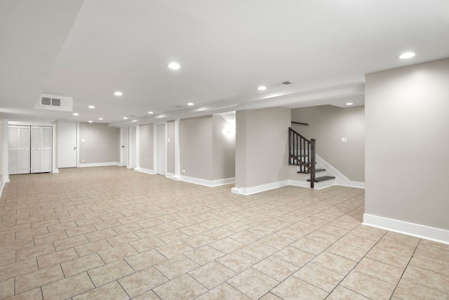 finished below grade area with visible vents, baseboards, stairway, light tile patterned floors, and recessed lighting