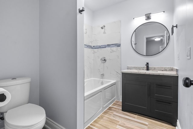 bathroom with vanity, toilet, wood finished floors, and shower / bathtub combination