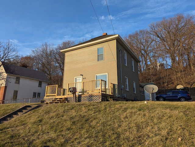 rear view of house with a deck and a lawn