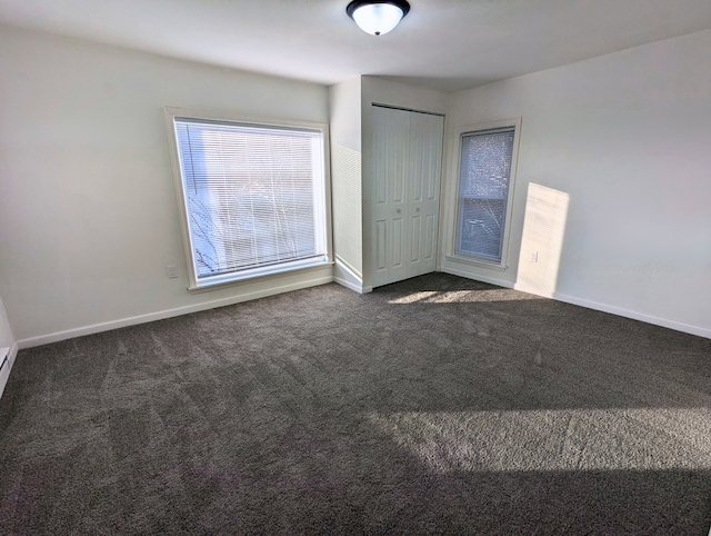 unfurnished bedroom with a closet and dark carpet