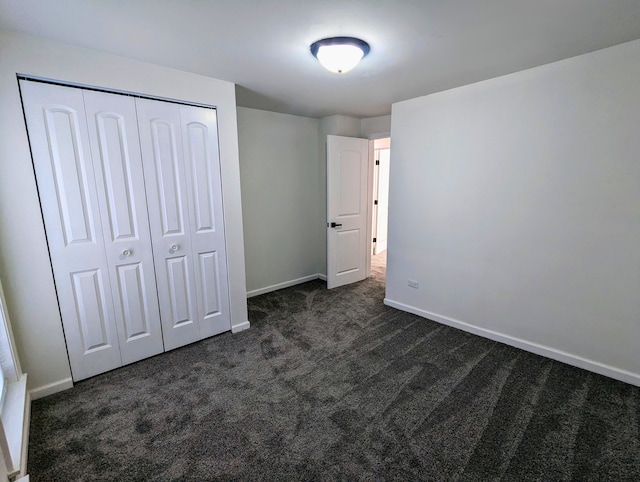 unfurnished bedroom featuring a closet and dark carpet