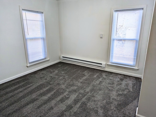 carpeted empty room featuring a baseboard heating unit