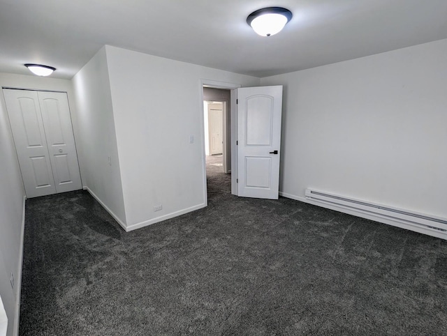 unfurnished room with a baseboard radiator and dark colored carpet