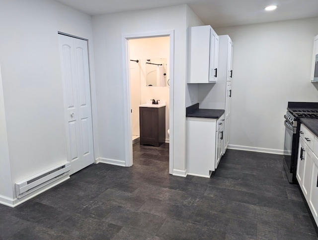 kitchen featuring white cabinets, baseboard heating, and stainless steel range with gas cooktop