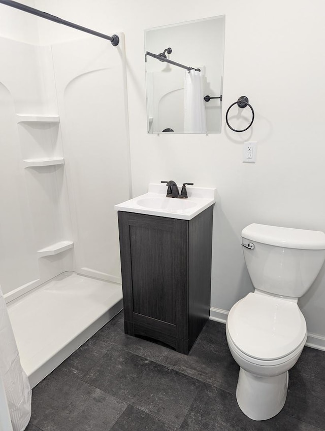 bathroom with toilet, vanity, and walk in shower