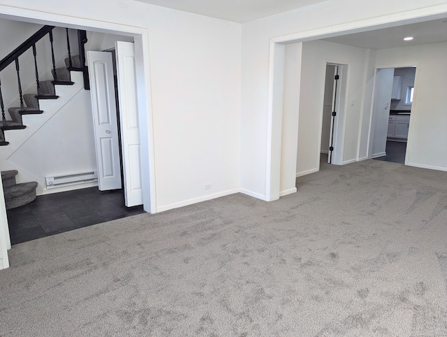 carpeted empty room featuring baseboard heating