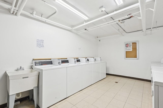 laundry area featuring light tile patterned flooring, sink, and washing machine and clothes dryer