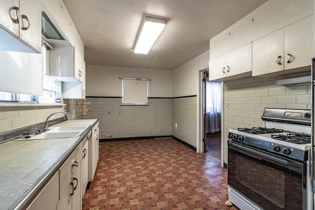 kitchen featuring white cabinets, tile walls, sink, and range with gas cooktop