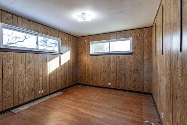 spare room with wooden walls and wood-type flooring