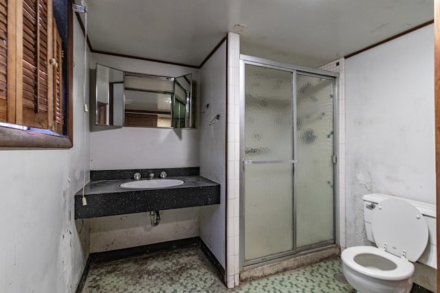 bathroom with toilet, an enclosed shower, and sink