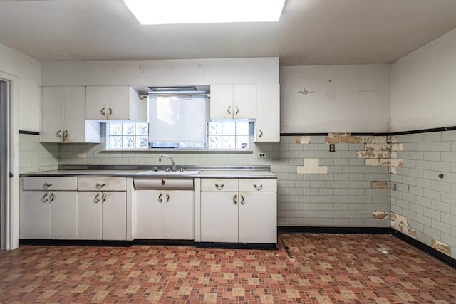 kitchen featuring white cabinets, decorative backsplash, and sink