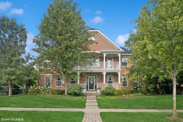 view of front facade featuring a porch, a balcony, and a front yard