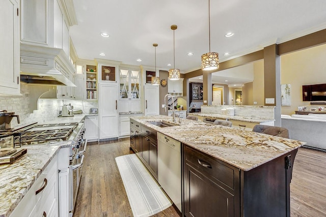 kitchen featuring a center island with sink, appliances with stainless steel finishes, pendant lighting, sink, and dark brown cabinets