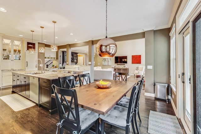 dining space featuring crown molding, dark hardwood / wood-style flooring, and sink