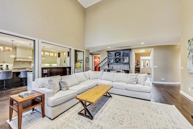 living room featuring a towering ceiling and hardwood / wood-style flooring